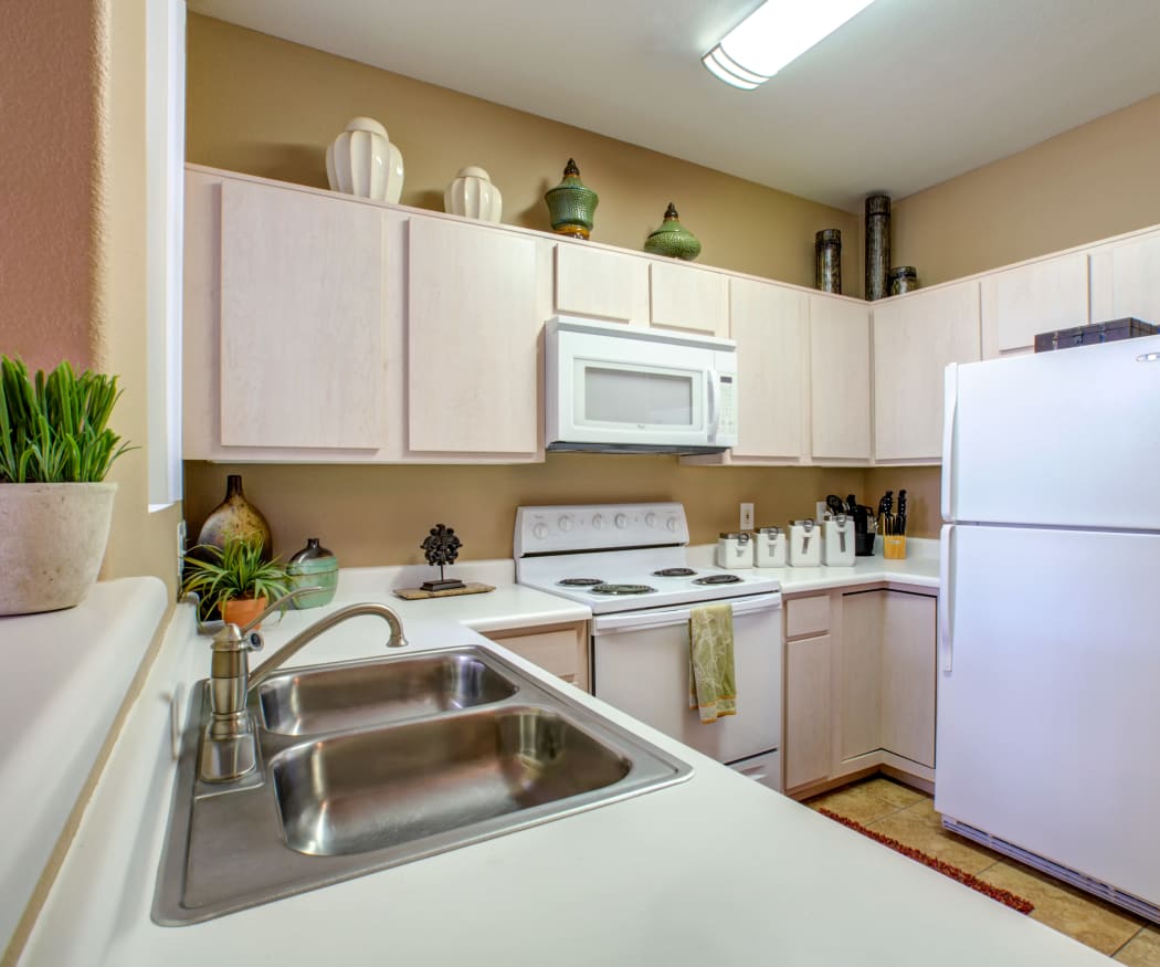 Light wood cabinetry and granite-style countertops in a model home's kitchen at Sierra Canyon in Glendale, Arizona