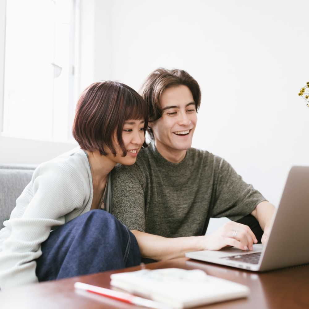 Couple working happily in the living room at Huntington Reef in Huntington Beach, California