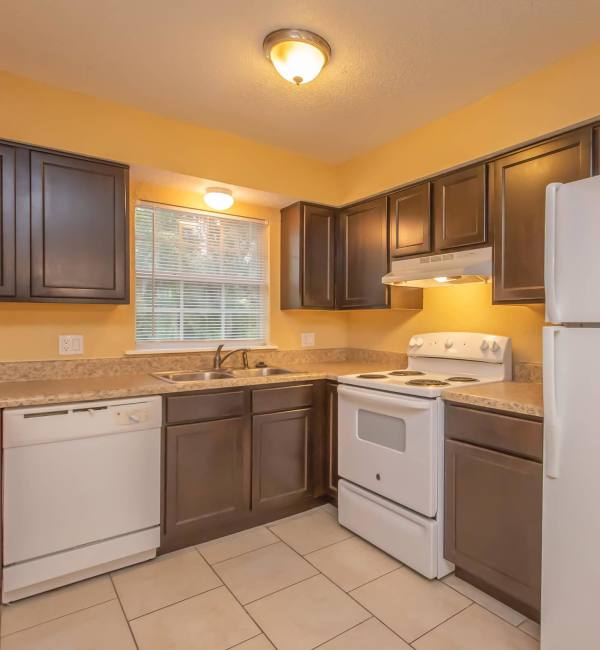 Well equipped kitchen with white appliances at Serenity Apartments in Leesburg, Florida