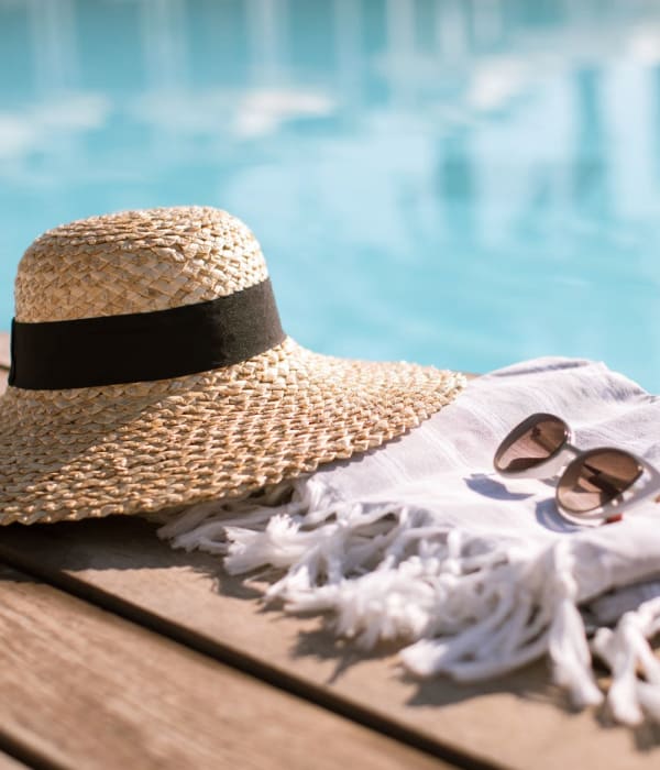 Hat, sunglasses, and towel by the pool at Vespaio in San Jose, California