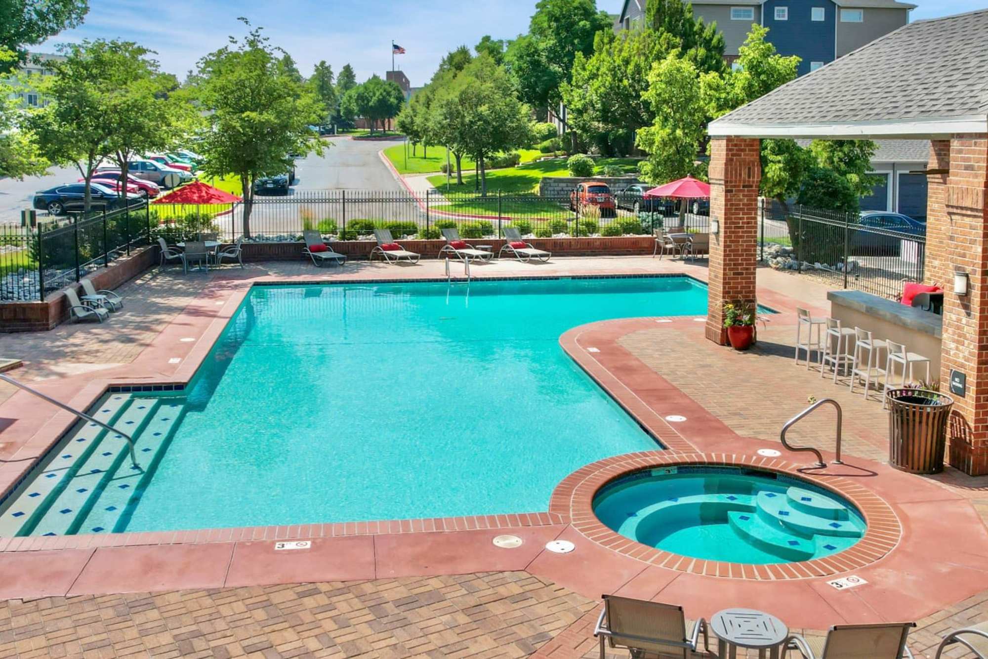 Swimming pool with greenery around at Promenade at Hunter's Glen Apartments in Thornton, Colorado
