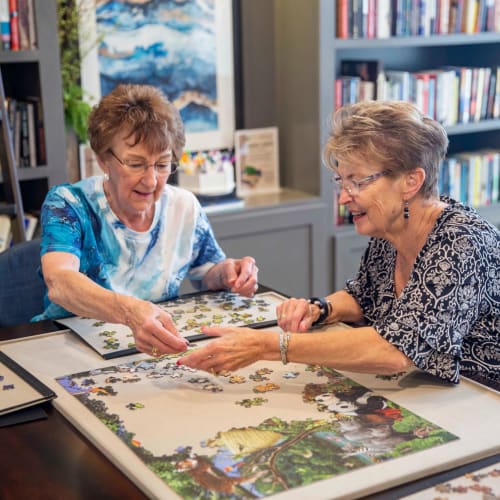 Two residents doing a puzzle together at Attivo Trail Waukee in Waukee, Iowa