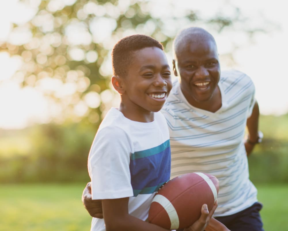 A father playing football with his son at North Severn Village in Annapolis, Maryland