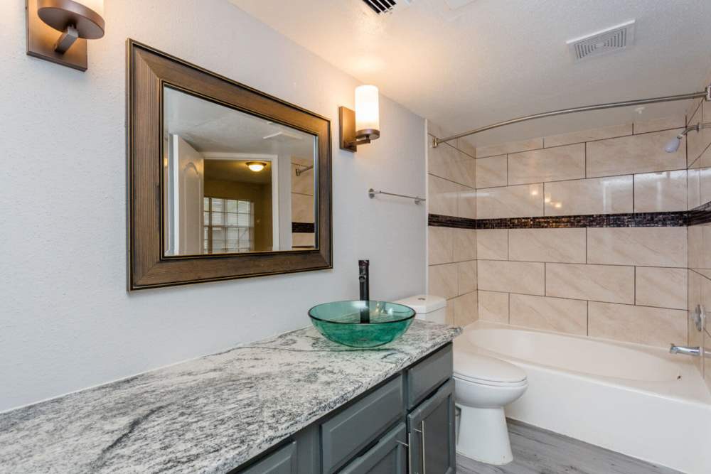 Bathroom with a toilet and a bathtub at Pine Lake Village in Houston, Texas