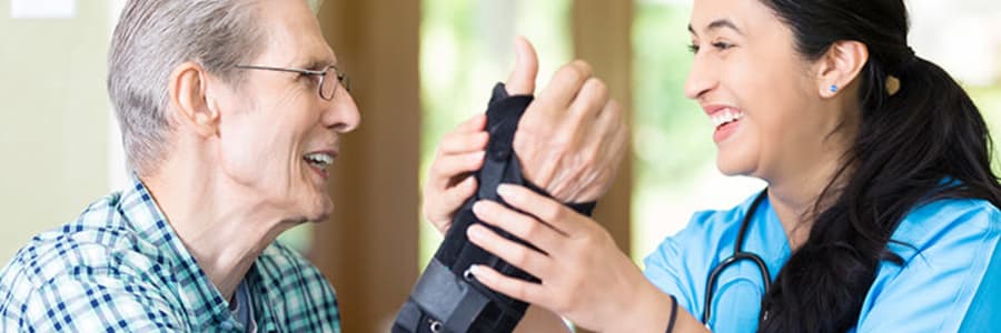 Nurse helping resident with an arm brace near Transitions At Home - West in Mount Horeb, Wisconsin