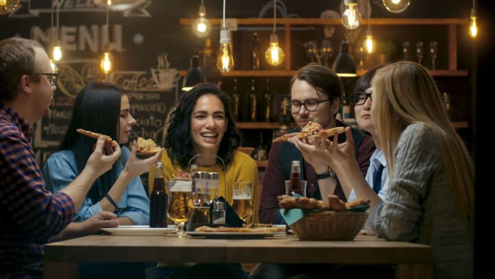 A group of friends eating pizza in a local restaurant