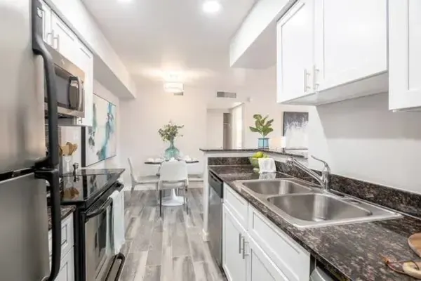 Kitchen with stainless steel appliances and white cabinetry at Onnix in Tempe, Arizona