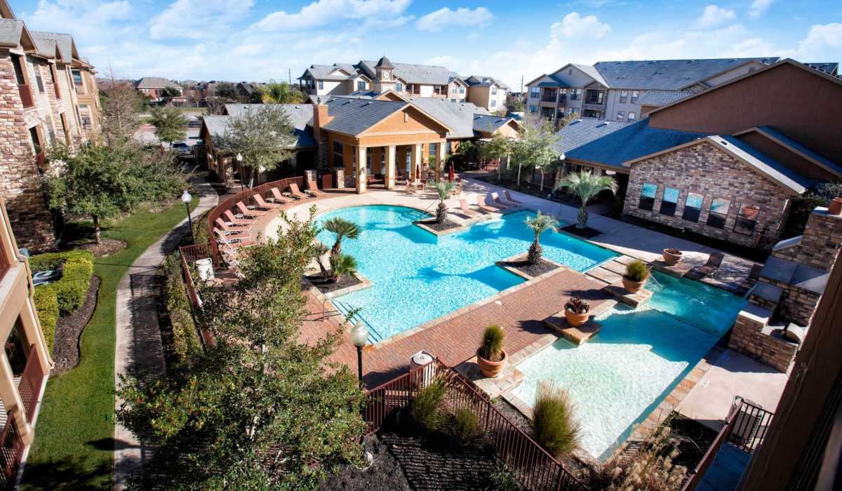 Drone view of garden style apartments with two charming pools at Cobblestone Park in Manvel, Texas