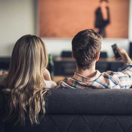 Couple relaxing on a couch, enjoying a movie night in a cozy living room at Monarch Station in Louisville, Kentucky