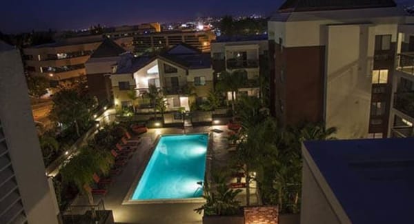 Nighttime view of the pool from a private balcony at 15Fifty5 Apartments