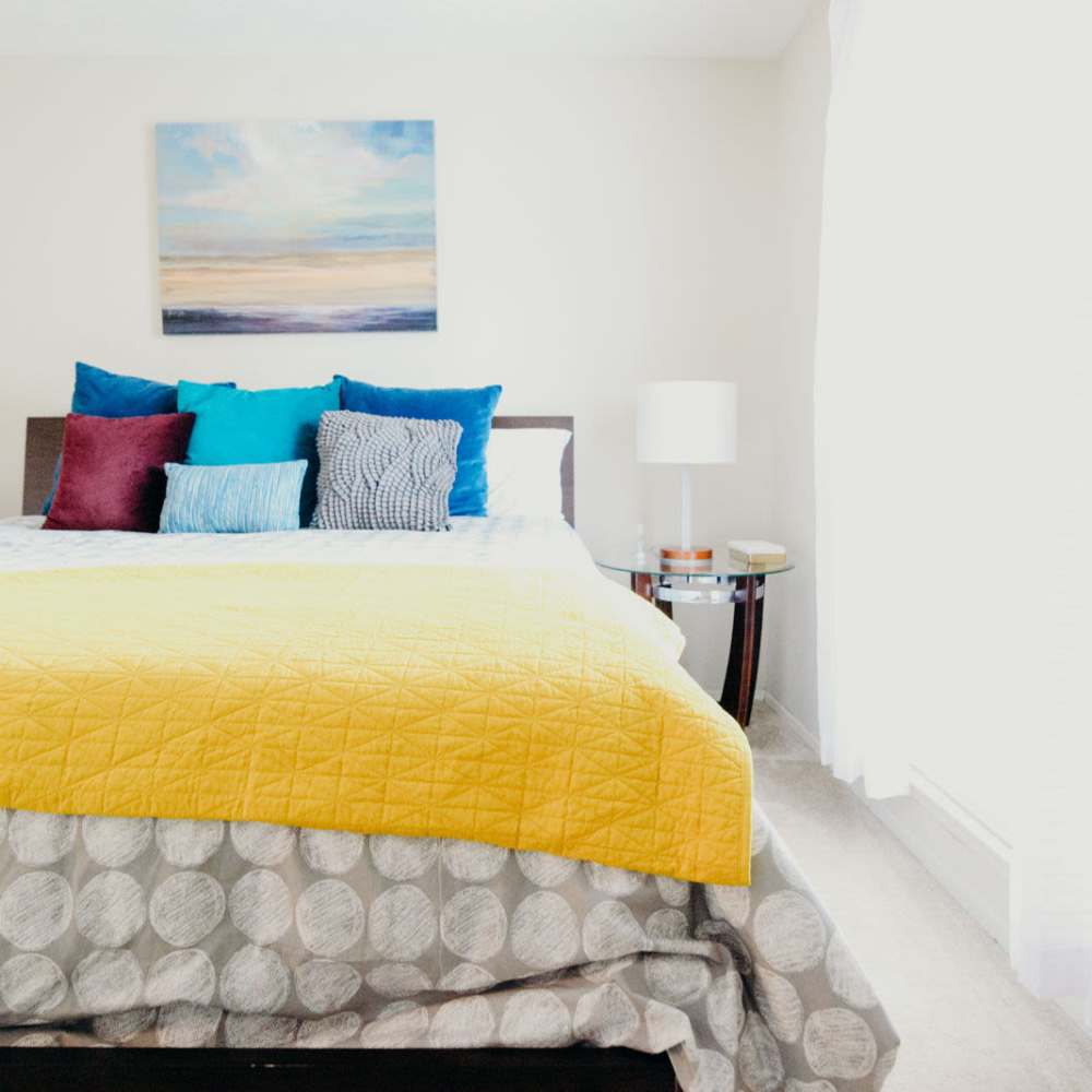 Bedroom with a night stand and curtains covering the windows at Tapestry on Vaughn in Montgomery, Alabama