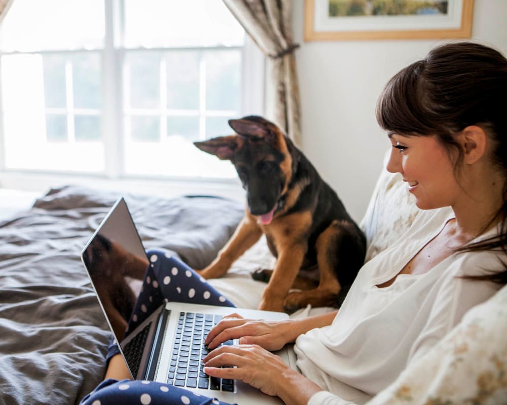 Resident surfing the web with her puppy in their new home at Parc at Wesley Chapel in Wesley Chapel, Florida