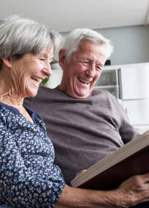 Residents looking through a photo book at The Pineapple House at Sapphire Lakes in Naples, Florida