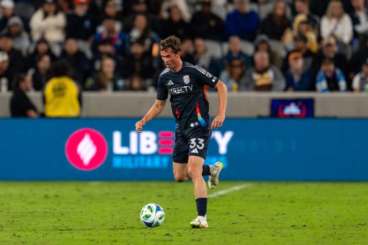 San Diego FC Player kicking a ball in front of the Liberty Military Housing Logo