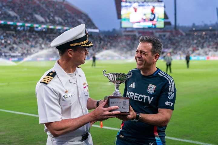 Philip Rizzo handing the award of "Hero of the Match" to its recipient  