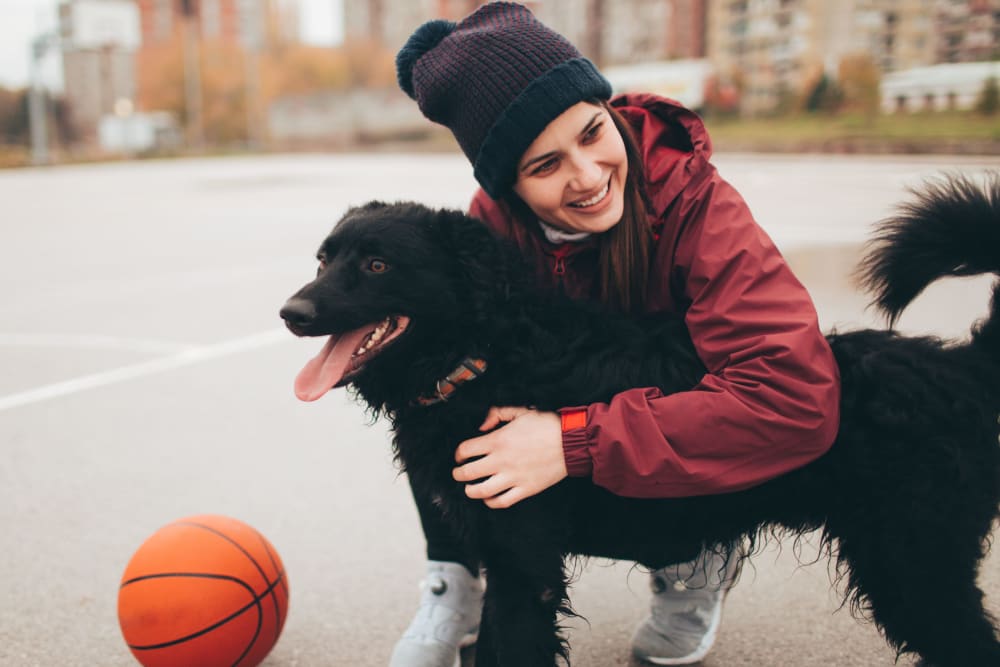 Resident playing basketball with her dog at a park near parcHAUS AT CELINA PARKWAY in Celina, Texas