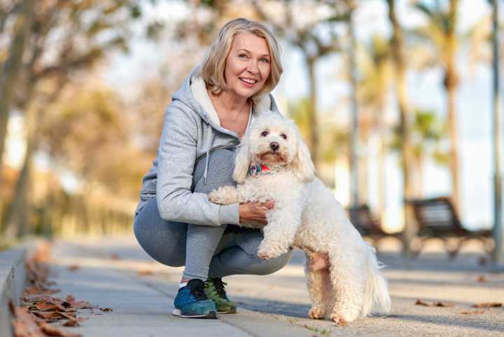 Active adult woman with her dog on a walking trail