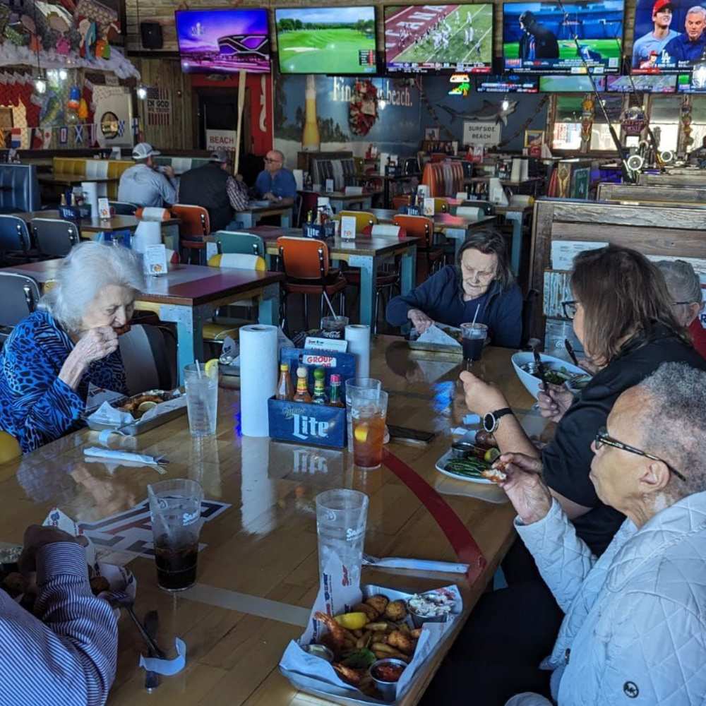 Residents dining together at a local restaurant during an outing from The Landing at Shadow Creek Ranch.