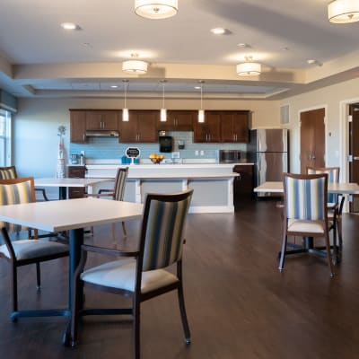 Modern community space with kitchen and tables for gathering at The Sanctuary at St. Cloud in St Cloud, Minnesota