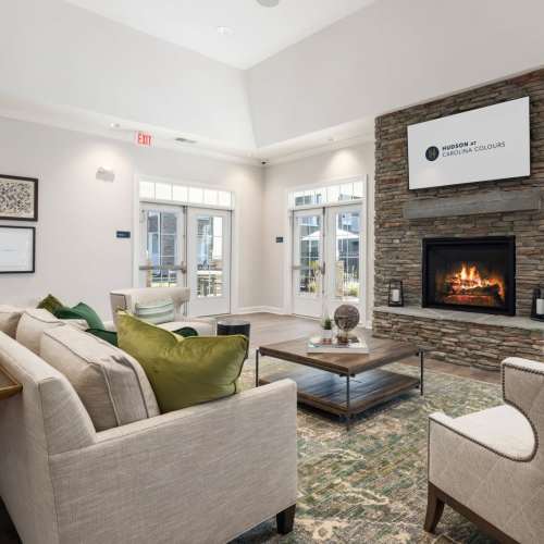 Brightly lit and open living room with carpet and large window at Hudson at Carolina Colours in New Bern, North Carolina