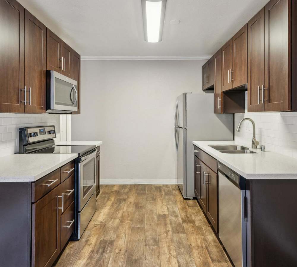 Kitchen with espresso cabinets, white quartz countertops and stainless steel appliances