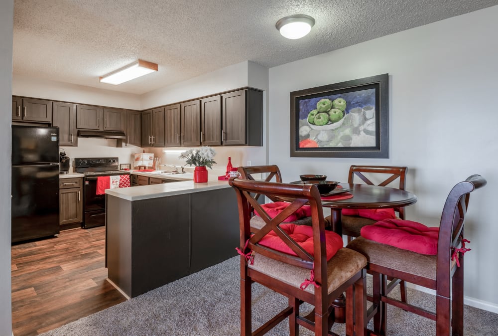 Kitchen with espresso cabinets and black appliances next to a dining area at River Park Tower Apartment Homes in Newport News, Virginia
