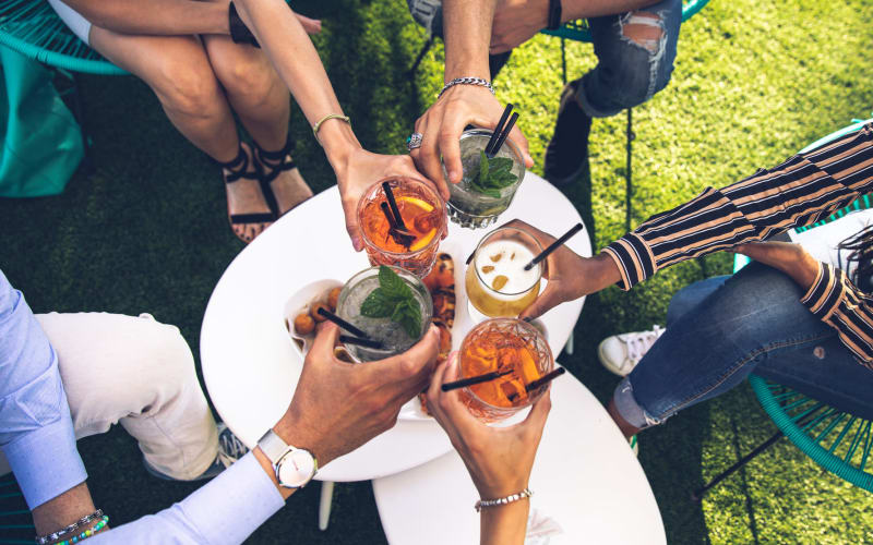 Friends having drinks on a lawn near Kenect Phoenix in Phoenix, Arizona