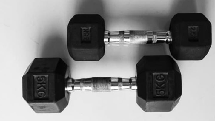 2 dumbbells lying on a white floor | Unsplash