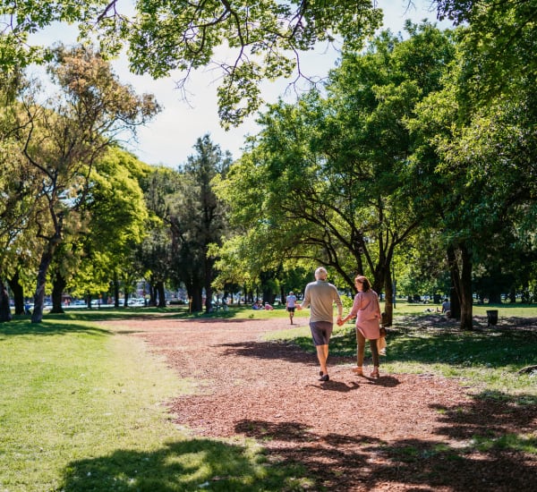 A couple walking through a park near Retreat at the Park in Burlington, North Carolina