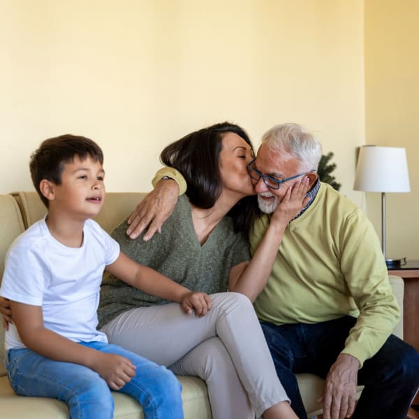 Family embracing in a living room at Pacifica Senior Living Sterling in Sterling, Virginia