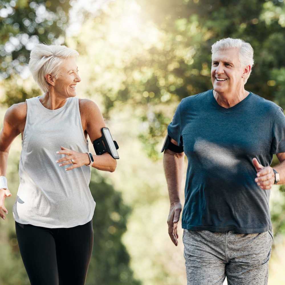 A senior resident couple jogging together at a park near The Manor At Union Crossing in Gastonia, North Carolina