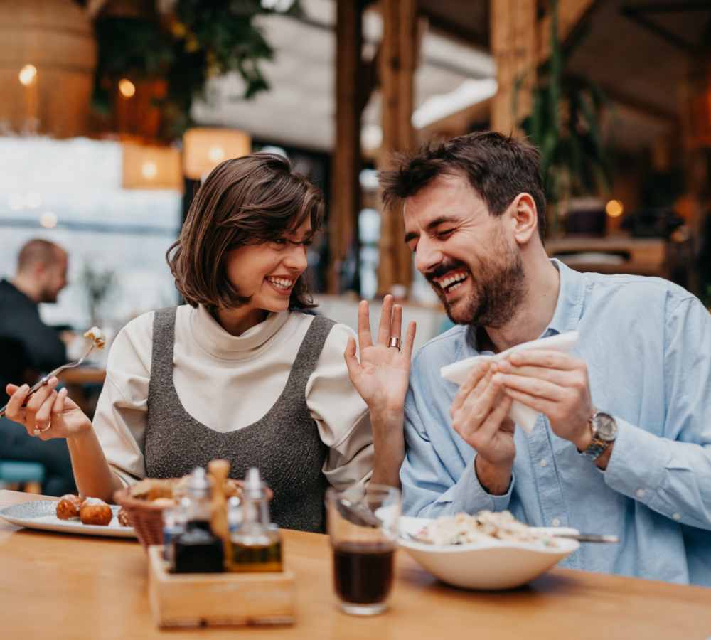 Couple laughing while sharing a meal at Avia Lofts at Maple Road in Amherst, New York 