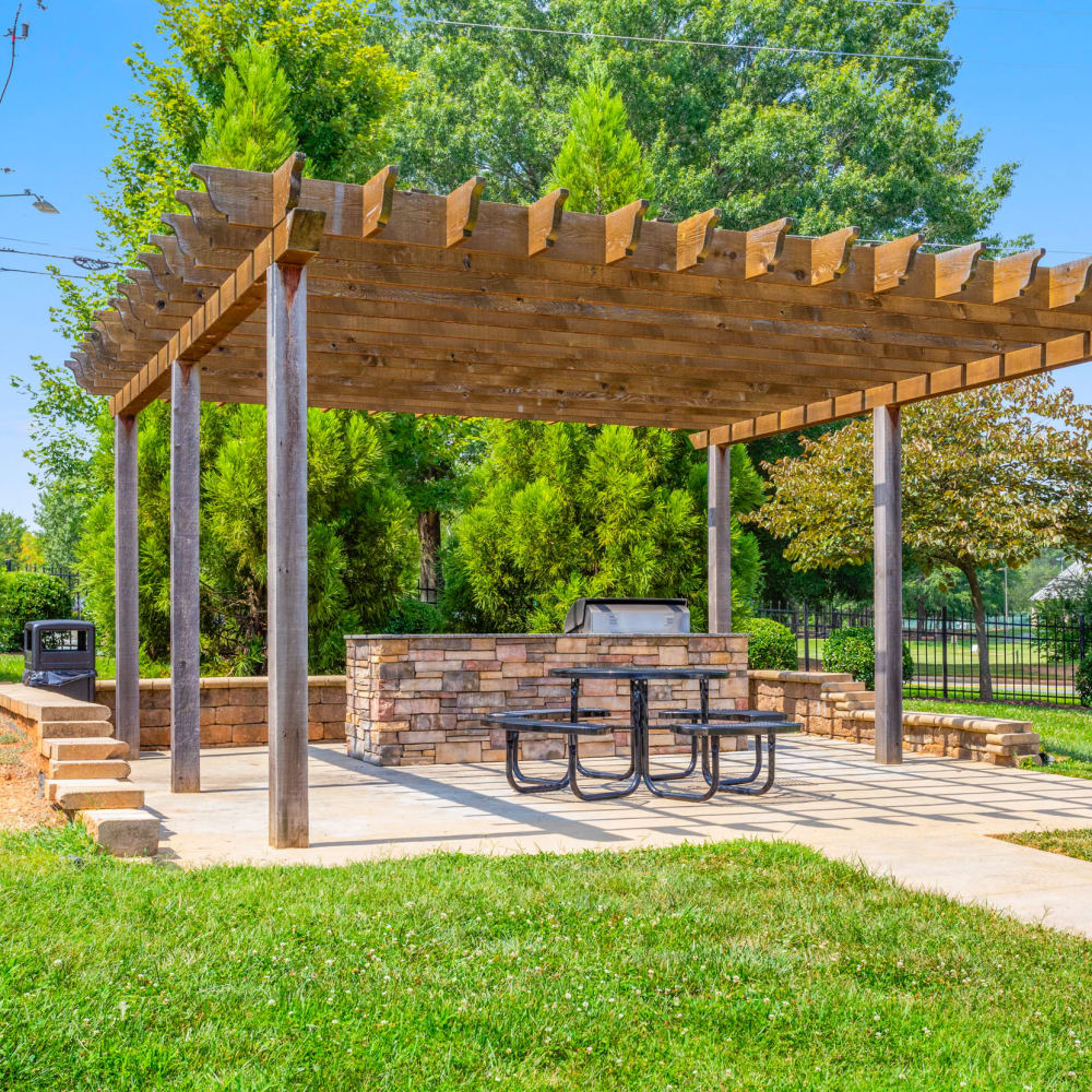Outdoor grill area with green grass at Retreat at the Park in Burlington, North Carolina