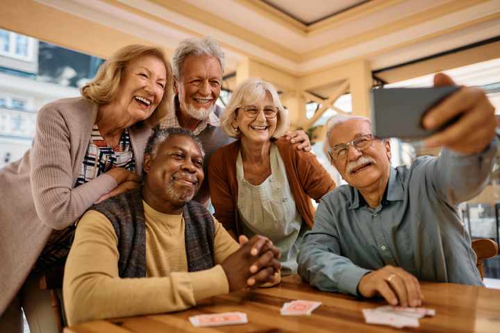 Residents enjoying a game night and group selfie at Watermere at the Preserve in North Richland Hills, TX, creating joyful memories.