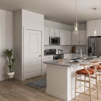 Upgraded stainless steel appliances and grey cabinets in an apartment kitchen at Cypress Creek at Lakeline in Cedar Park, Texas