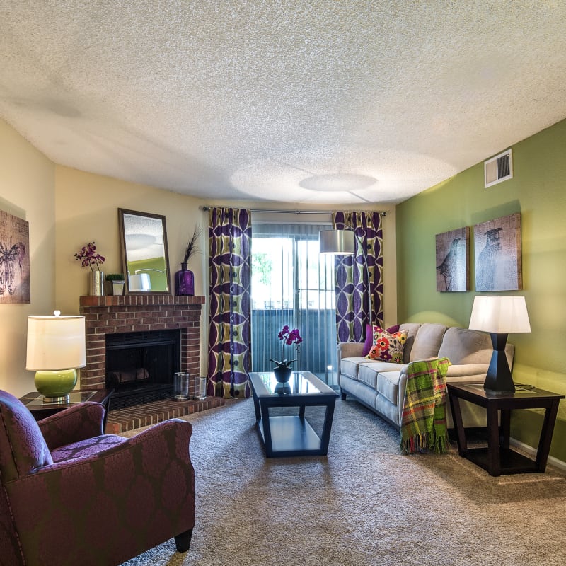 Well-furnished living area with a fireplace in a model home at Waterfield Court Apartment Homes in Aurora, Colorado