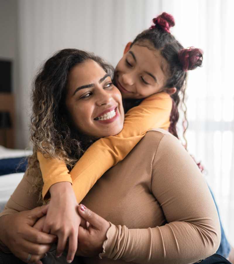 Resident smiling with her child at Milwee Street Apartments in Houston, Texas