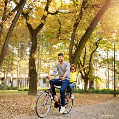 A resident with his child rides her bike near The Allara Apartments, Boynton Beach, Florida