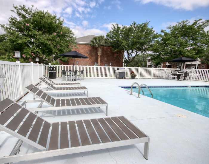 The community swimming pool surrounded by outdoor seating at Cloisters at Carolina Forest in Myrtle Beach, South Carolina