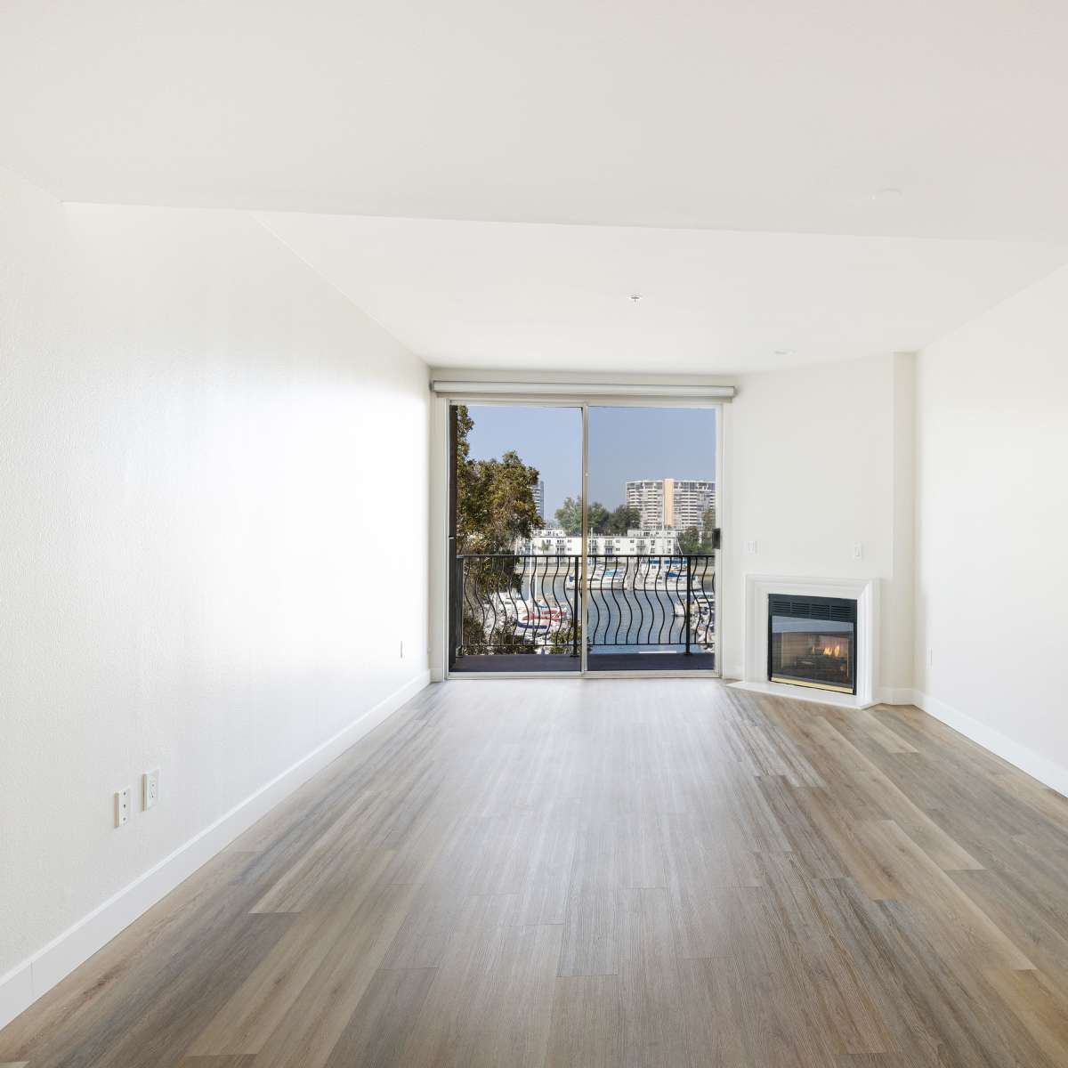 Spacious living room with fireplace and balcony at St Tropez Apartments in Marina Del Rey, California 