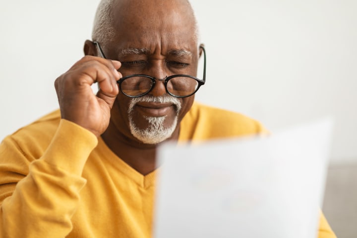 Senior African Man Squinting Eyes Reading Glasses
