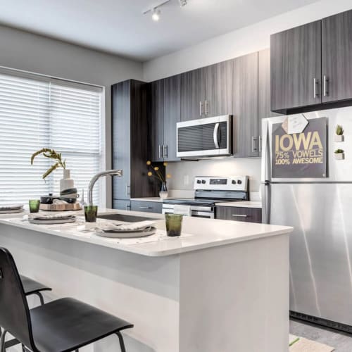 A modern apartment kitchen with an island at The Banks in Coralville, Iowa