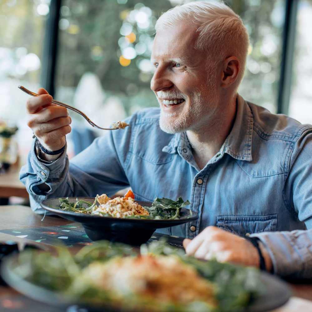 Man eating a delicious meal at Ellsworth Commons Apartments in Greenville, North Carolina