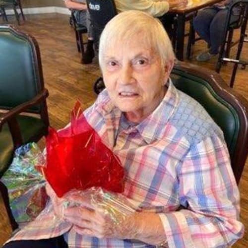 Resident presenting his wife a valentines day gift at Saddlebrook Oxford Memory Care in Frisco, Texas