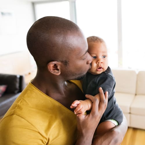 A resident father holding his son in a home at Perry Circle Apartments in Annapolis, Maryland