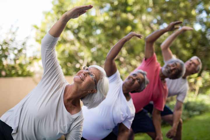 Residents enjoying outdoor yoga at Watermere at the Preserve in North Richland Hills, TX, promoting wellness and active senior living.