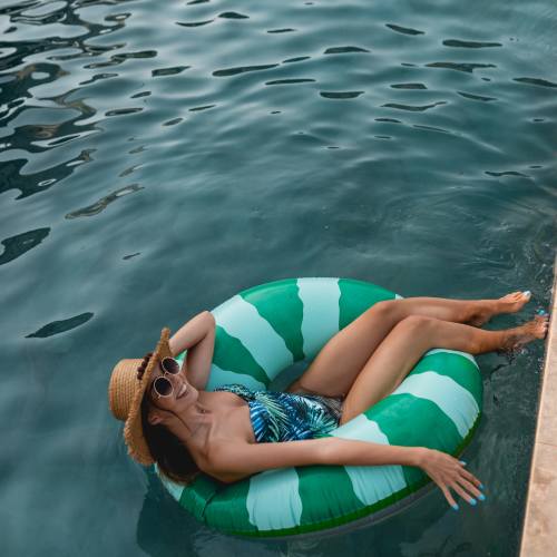 Resident relaxing on a flotation device in the pool at Sharps & Flats Apartment Homes in Davis, California
