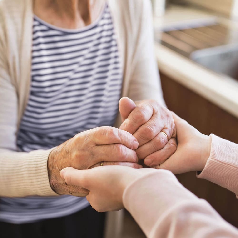 Resident and caretaker holding hands at Anthology of Louisville in Louisville, Kentucky