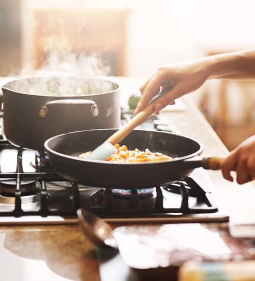 Resident cooking a meal in the kitchen at The Kensley in Spanish Fort, Alabama