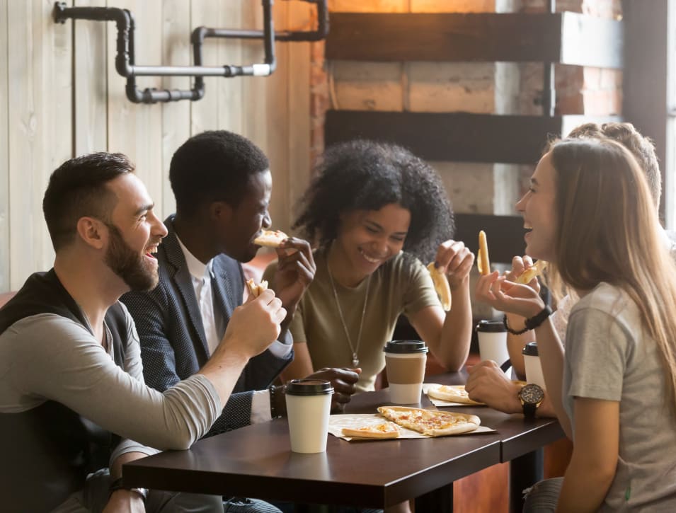 Resident friends enjoying a snack with their coffee at their favorite café near 2900 on First Apartments in Seattle, Washington